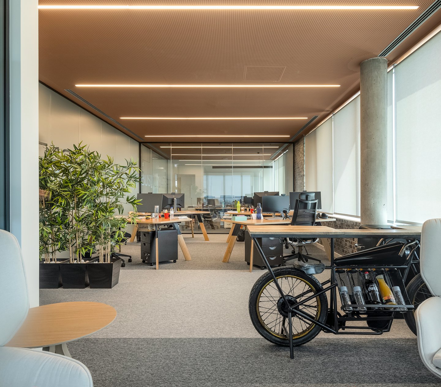 Modernt kontor med unikt motorcykel skrivbord och växter.