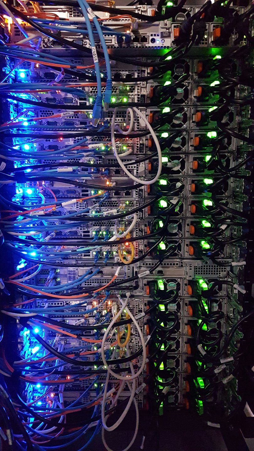 Serverrack med många färgglada kablar och lysande lampor.