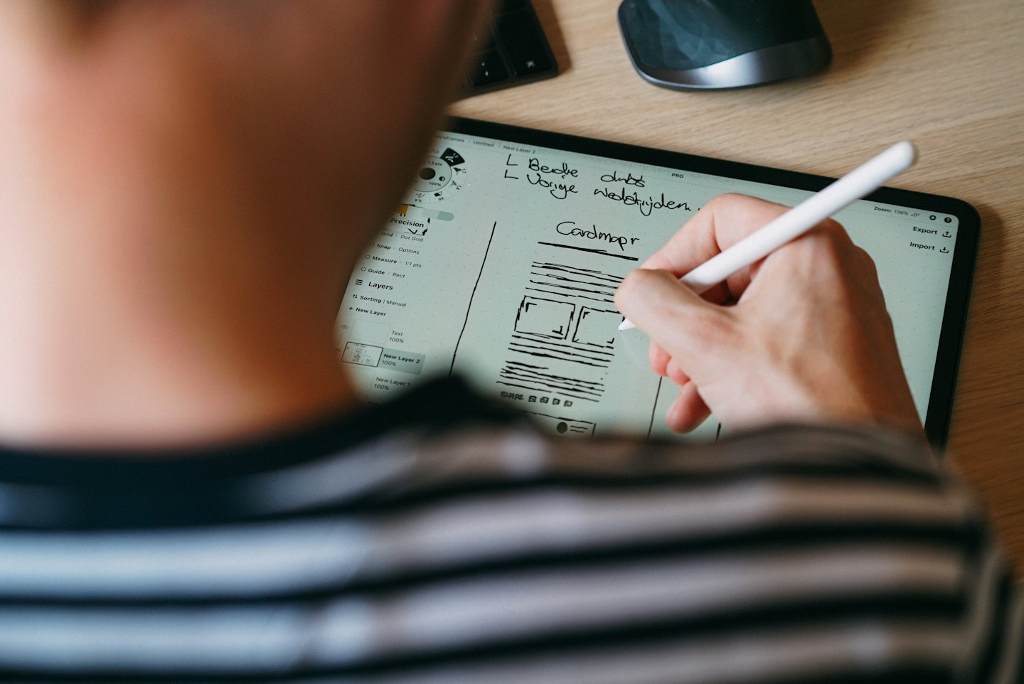 Person som ritar en wireframe på en surfplatta med en stylus.